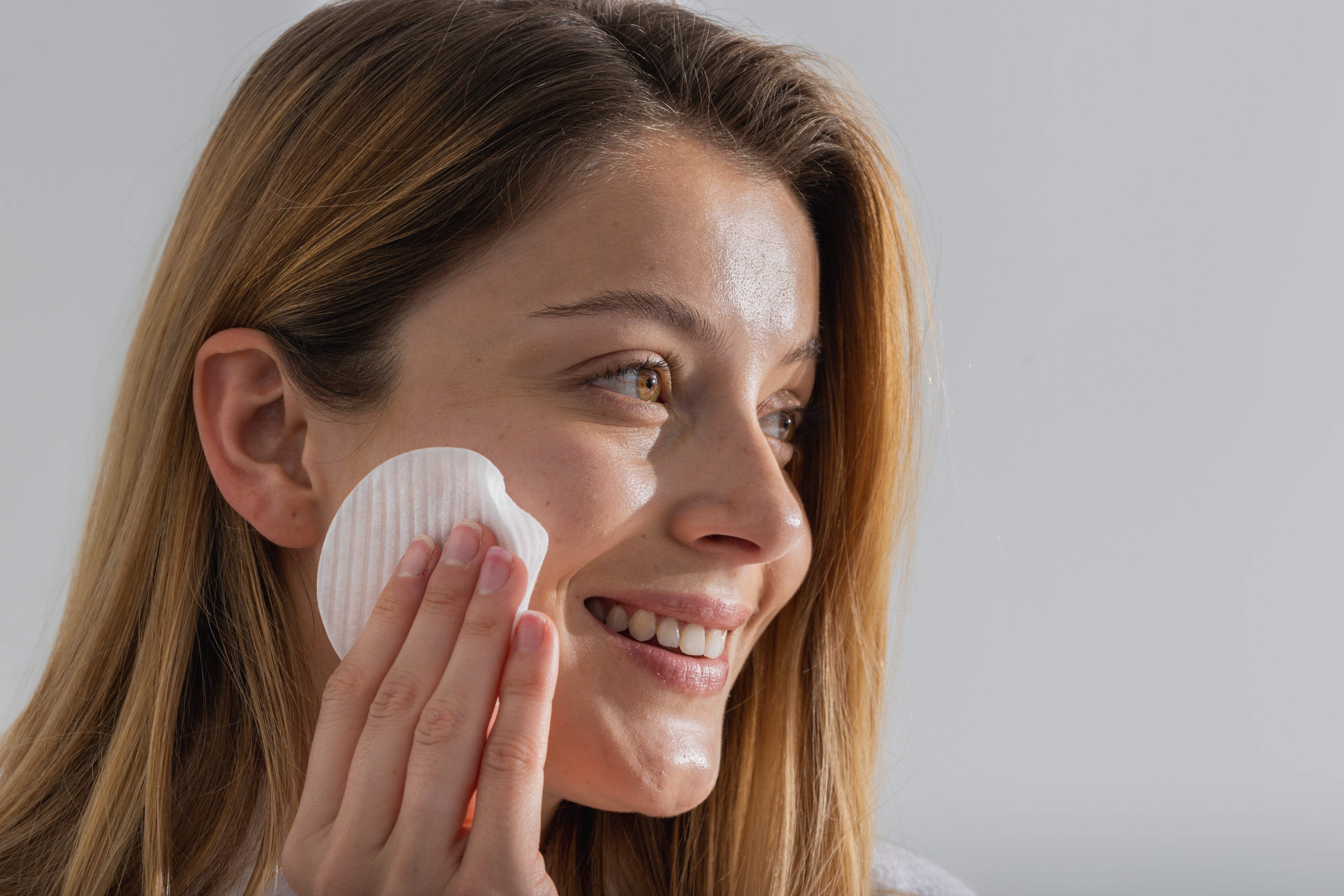 Woman cleaning her face with The Cleansing Pad by Scott + Sullivan