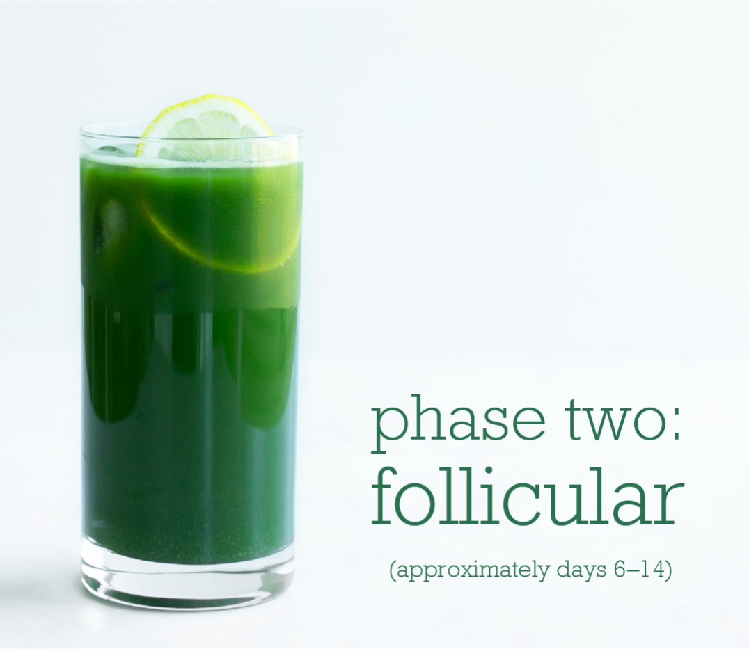 A tall glass of green juice with a slice of lemon