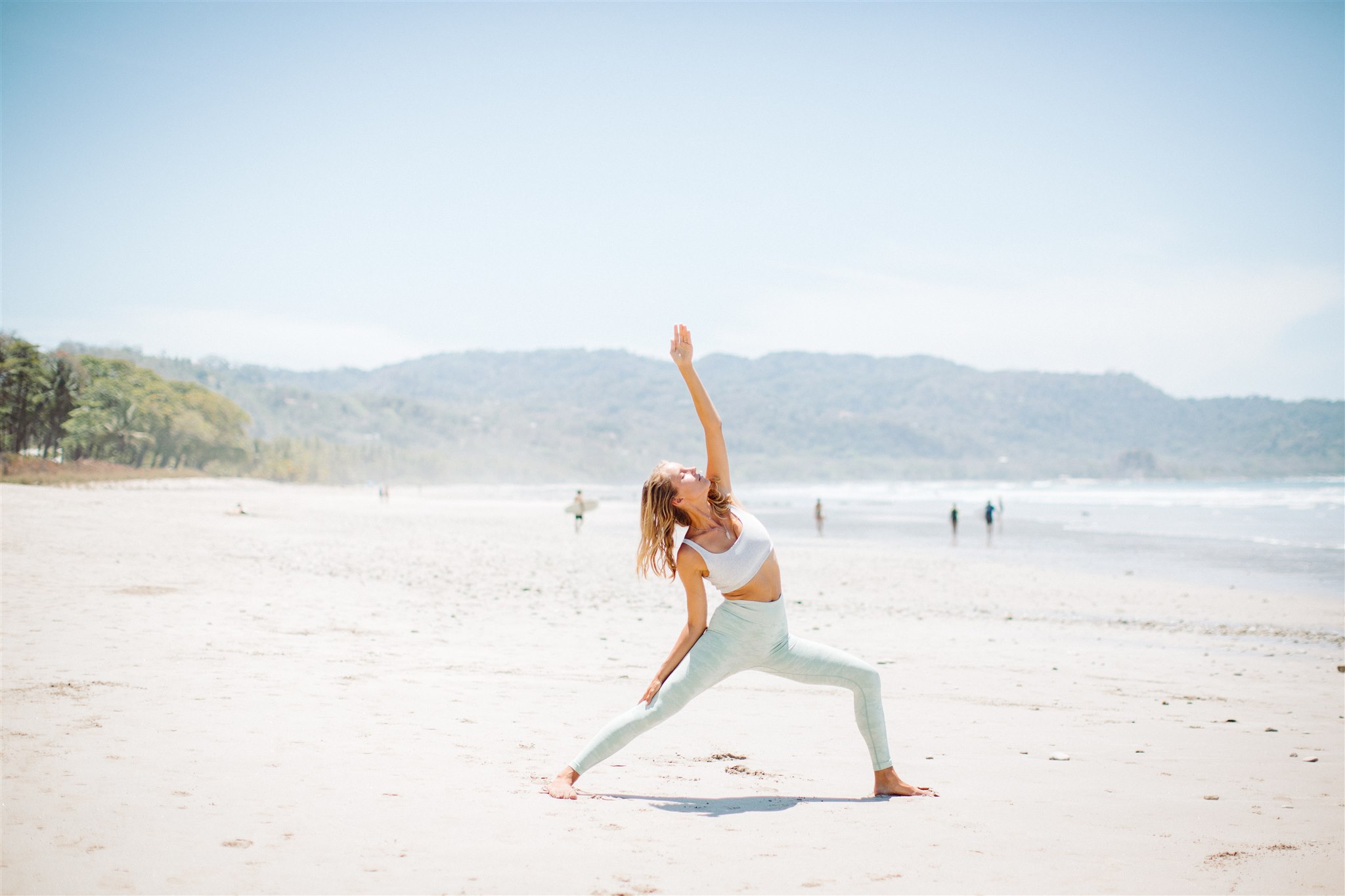 woman doing yoga on beach