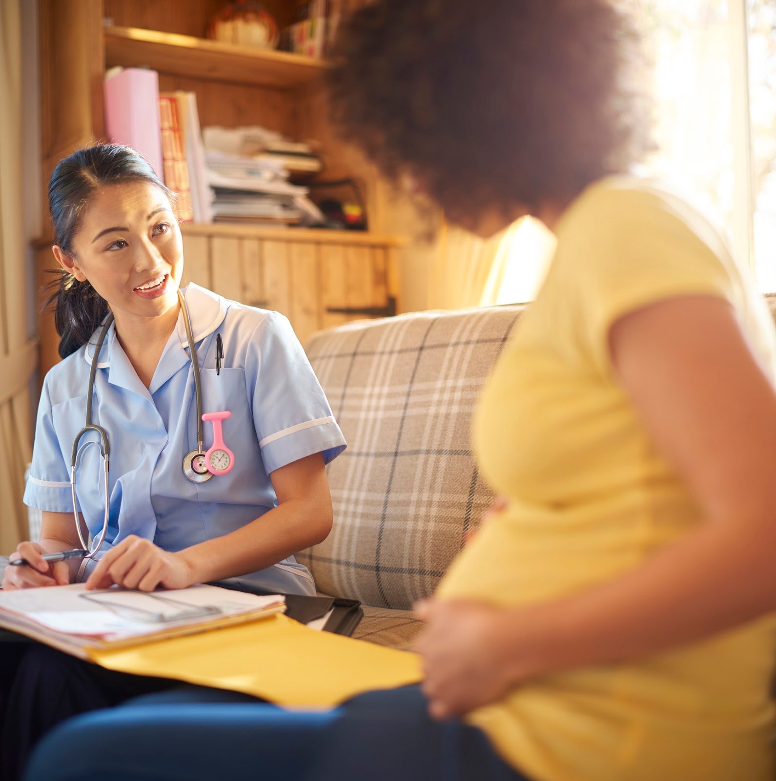 a pregnant woman speaking to her midwife about when to start antenatal classes