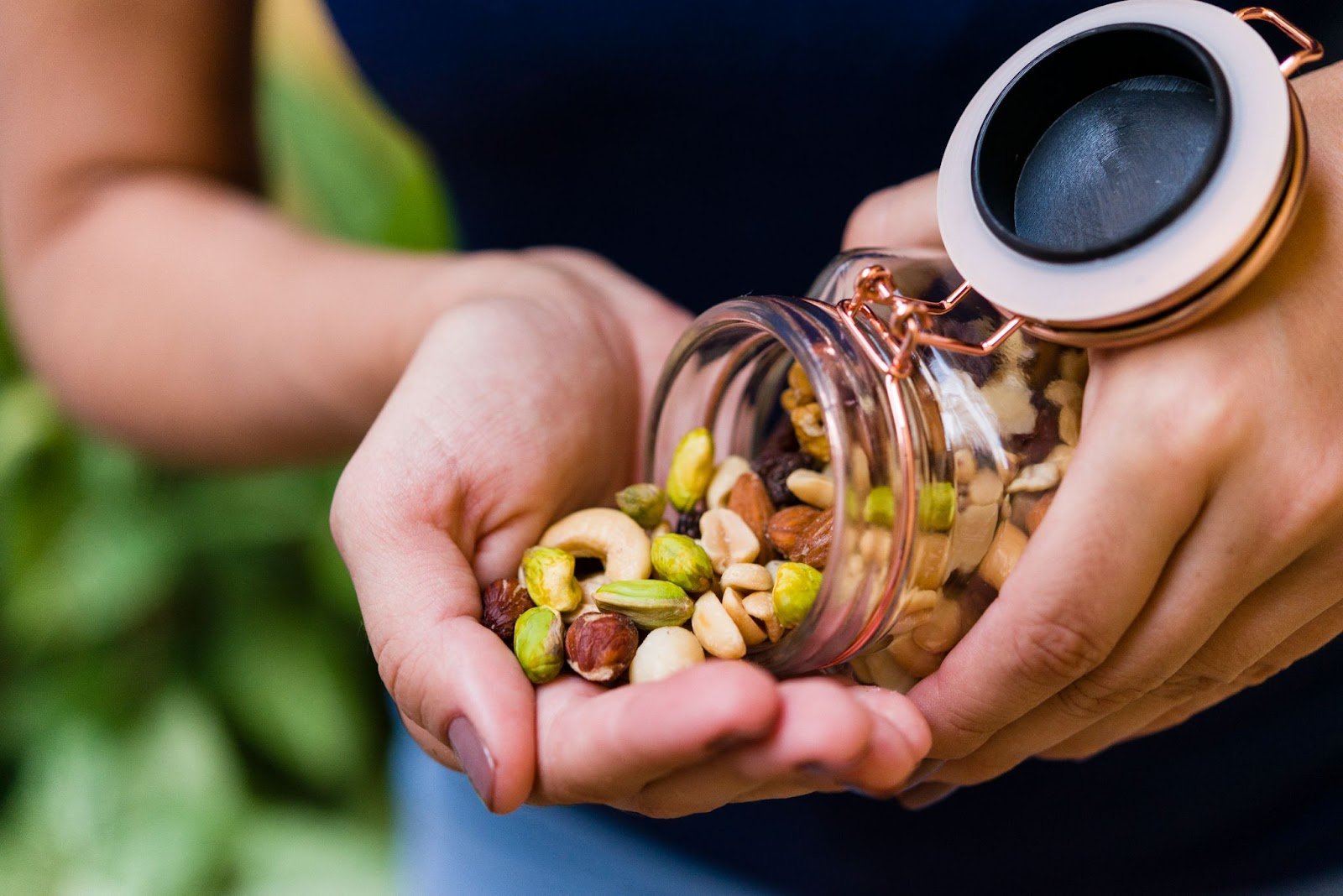 A woman is eating mixed nuts as part of a healthy, balanced diet in the first trimester of pregnancy.