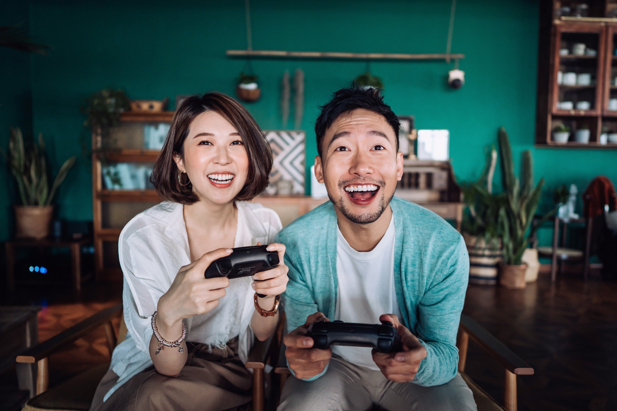 Happy couple playing video games to relax and reduce pressure