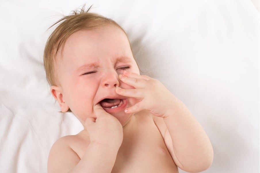 Baby crying from baby teething pain.