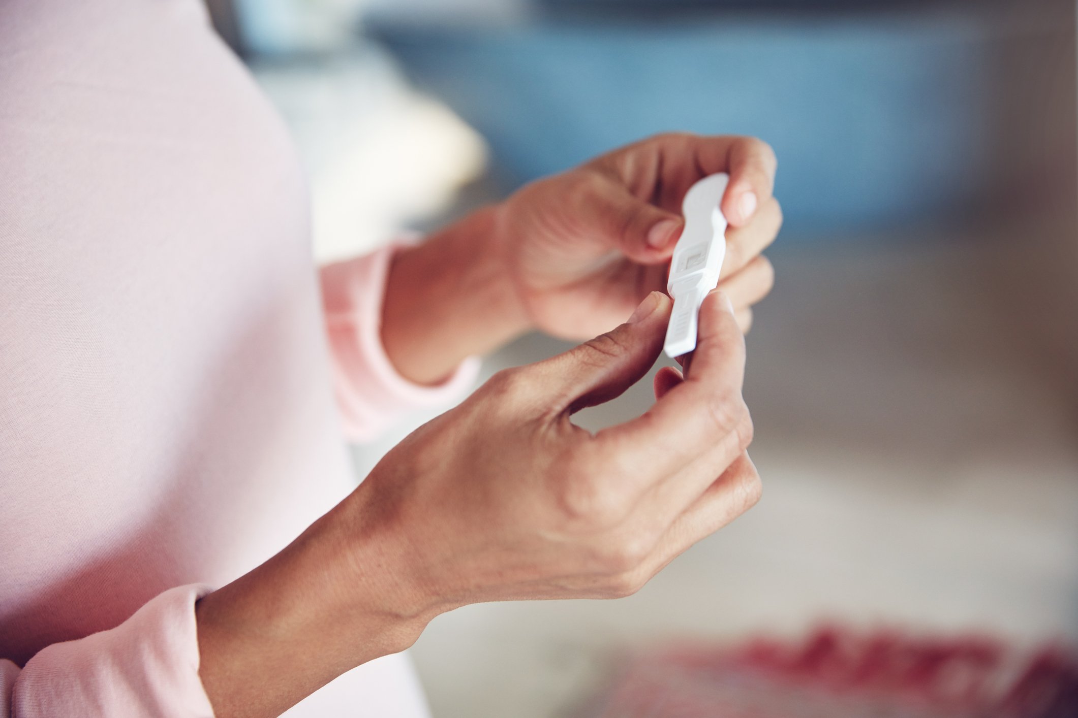 A woman takes an ovulation test after experiencing symptoms of ovulation.