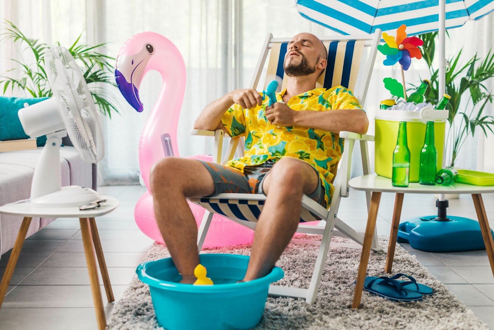 A man is relaxing in a holiday scene in his home. He is sitting in a deck chair. Relaxation and lowering stress levels is key to improving your sperm count.