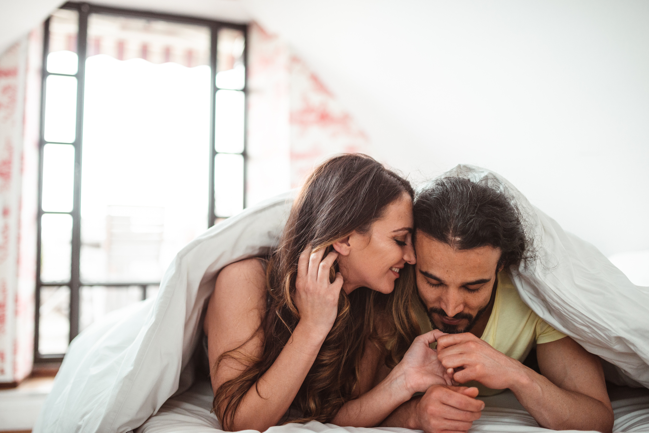 Couple in bed. A woman is more likely to feel sexual during ovulation.