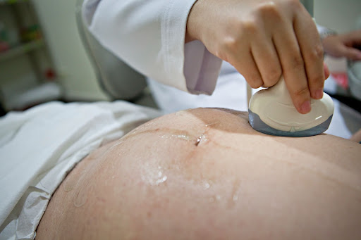 A pregnant woman is having an ultrasound scan at the antenatal clinic.