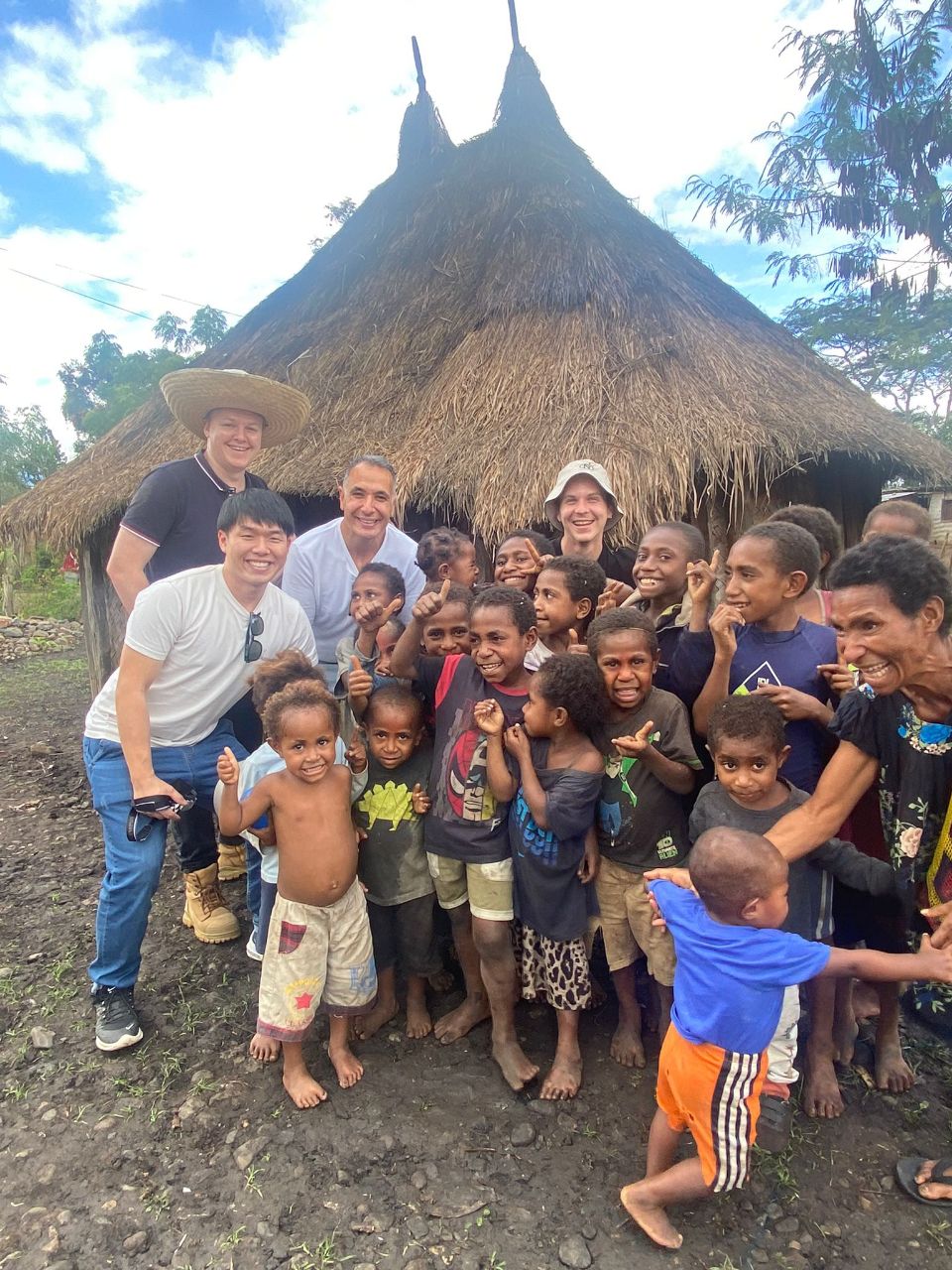 George taking a picture with smiling kids from a local village in the coffee growing region of PNG