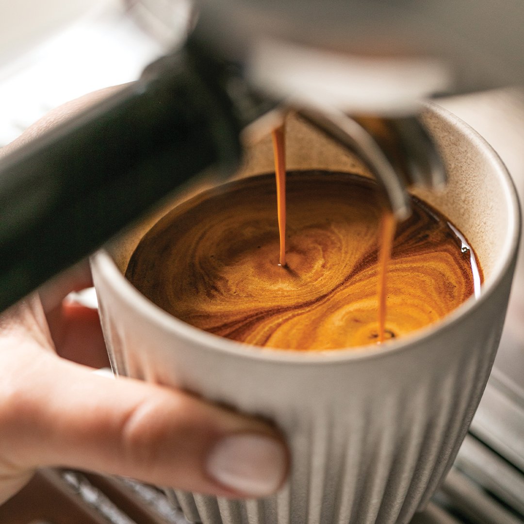 pouring espresso into a cup