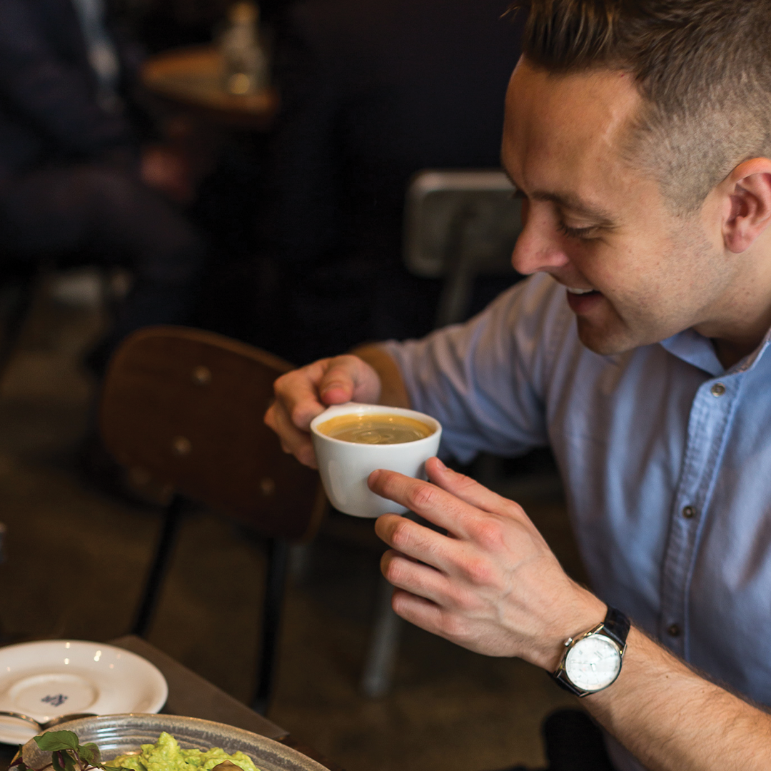 A happy customer enjoying his freshly brewed coffee