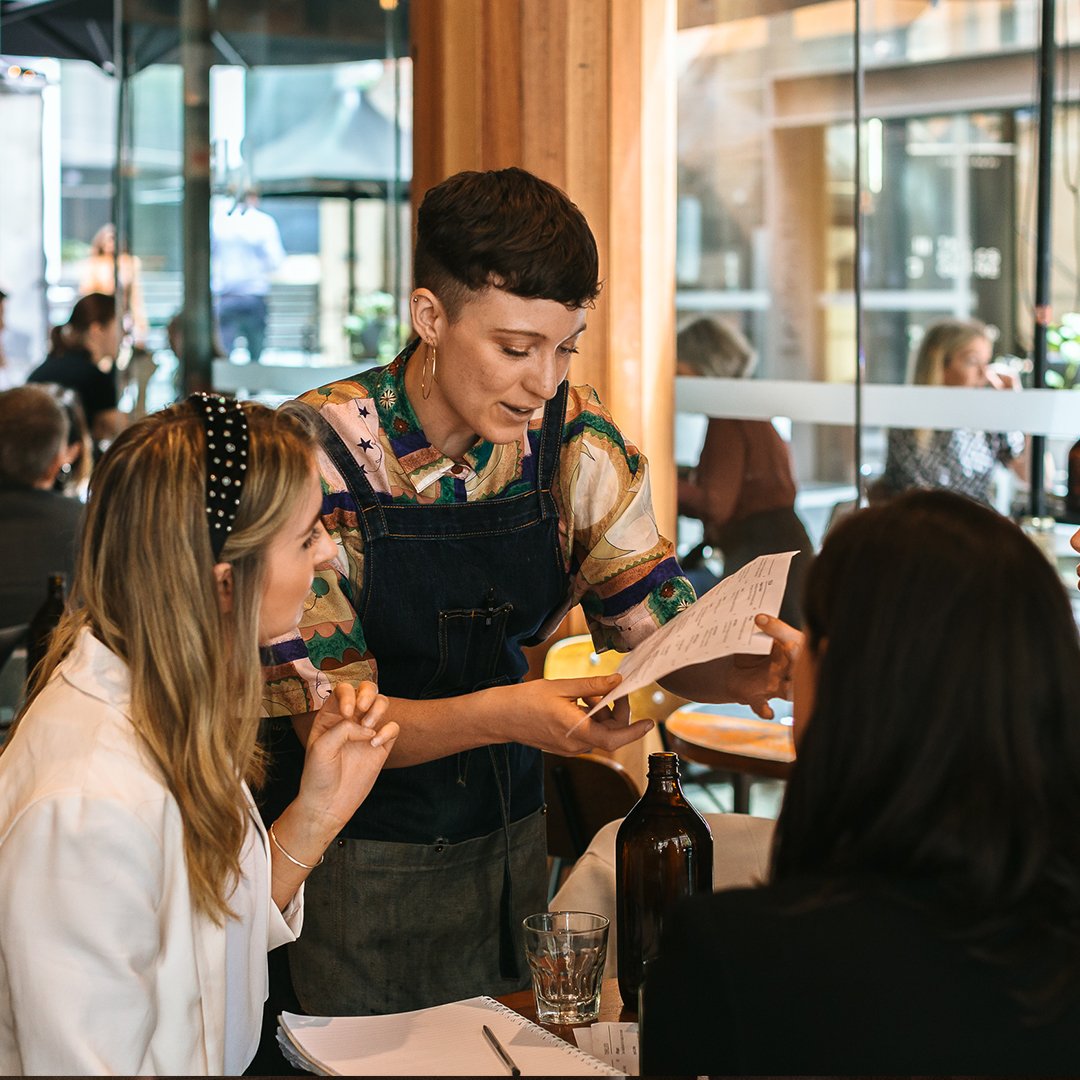 cafe staff explaining the menu to customers