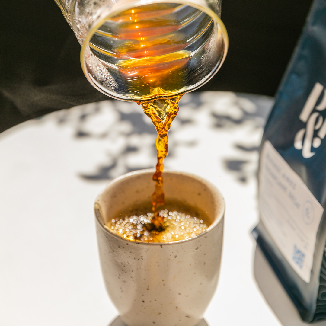 pouring brewed coffee into a cup