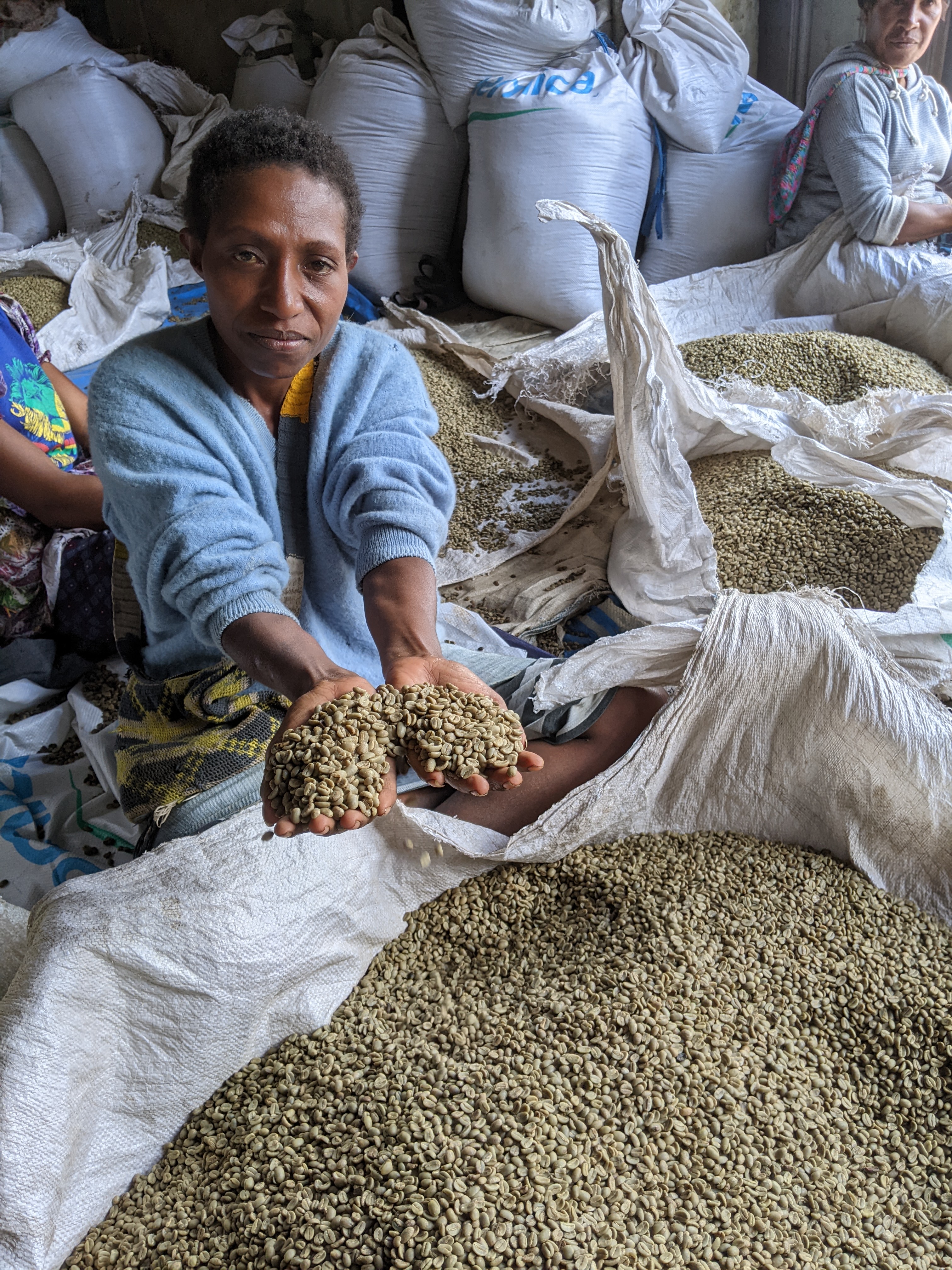 Local PNG worker sorting coffee beans by hand for quality