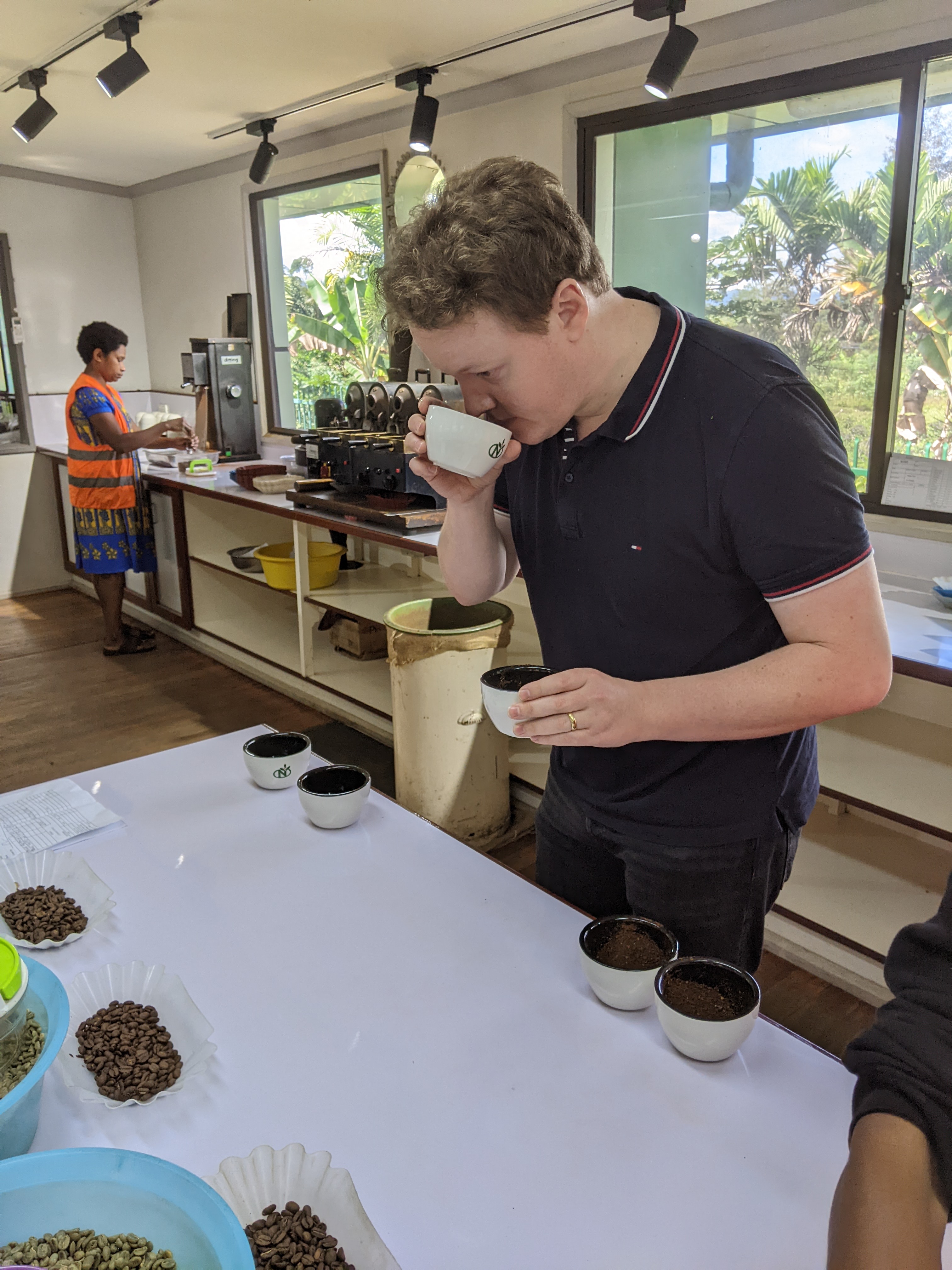 George smelling ground coffee beans during grading