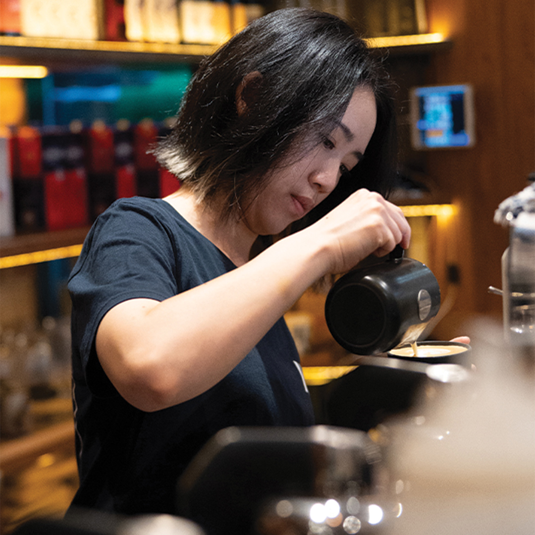 female barista pouring coffee