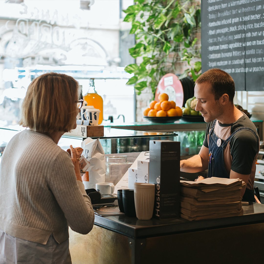 Cafe counter staff happily serving the customers
