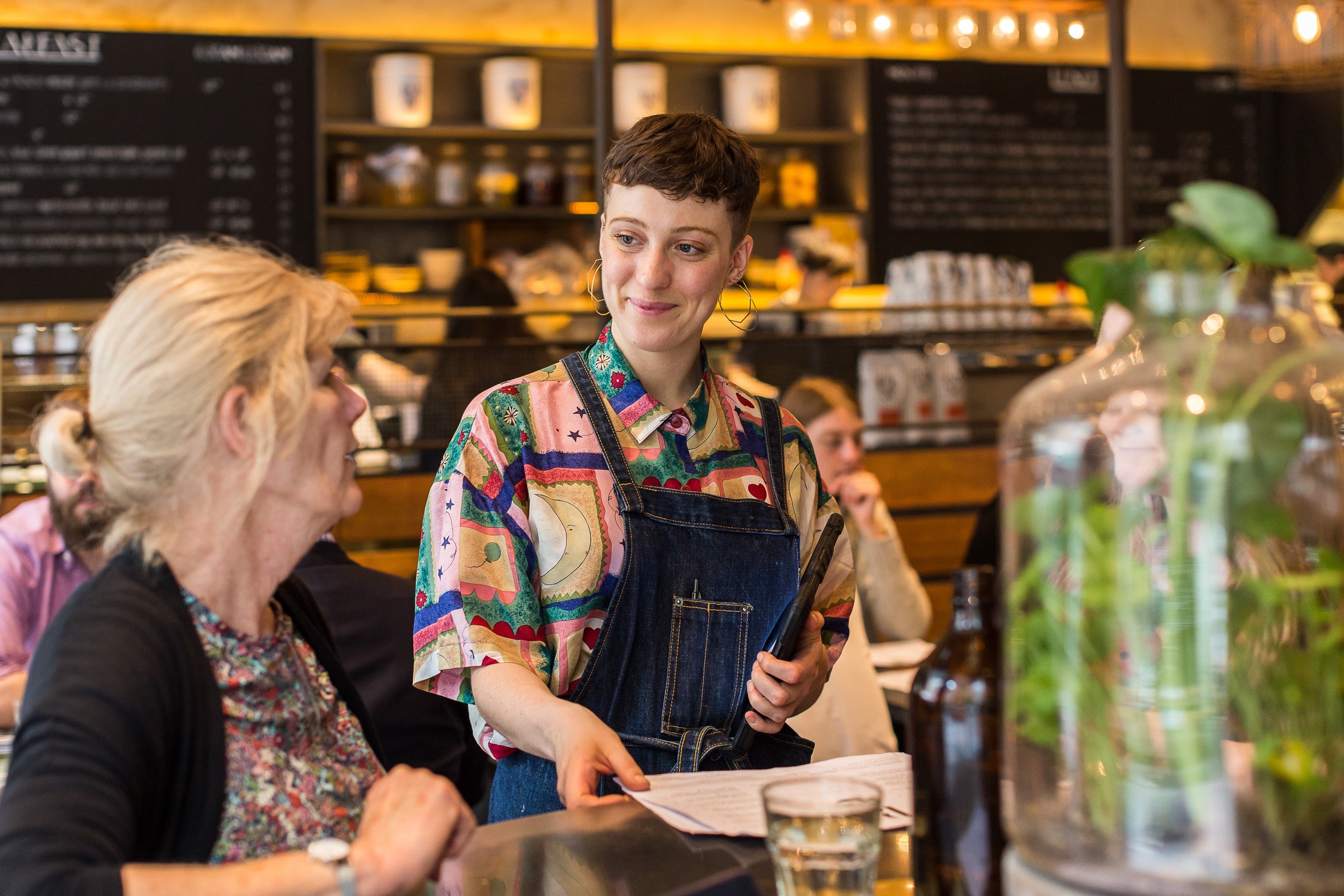 Cafe staff happily serving a customer