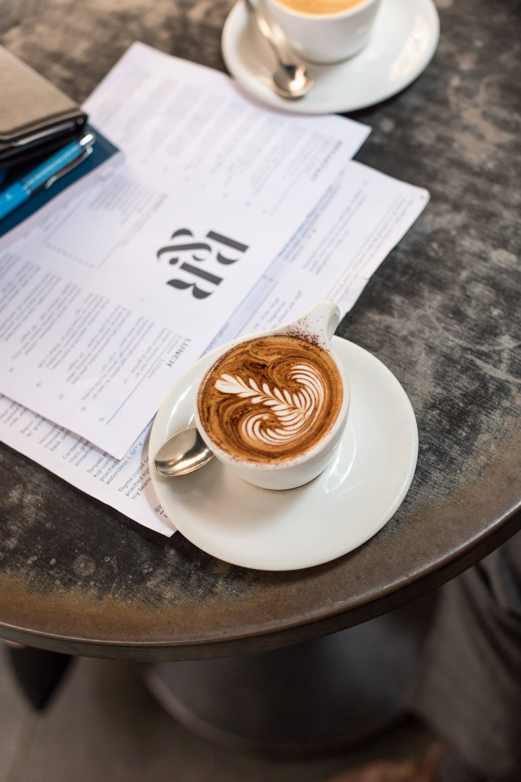 Coffee with latte art on top of a menu in a cafe