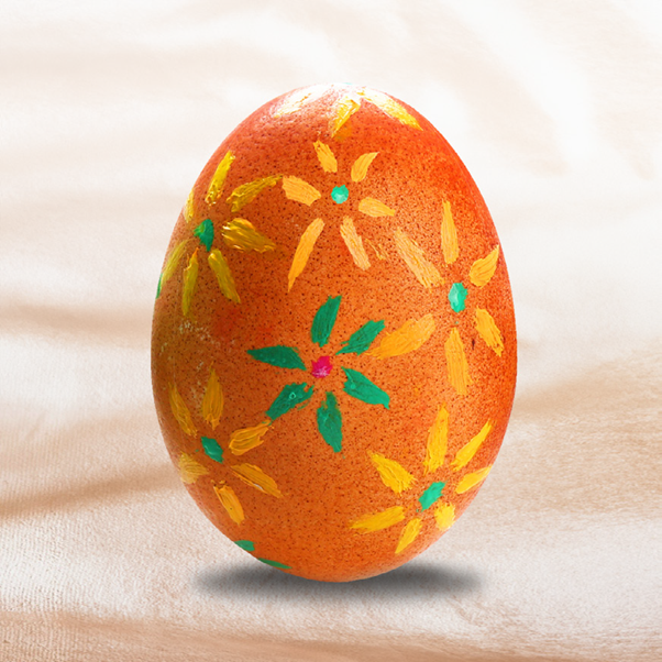 An egg painted with flowers in acrylic paint.
