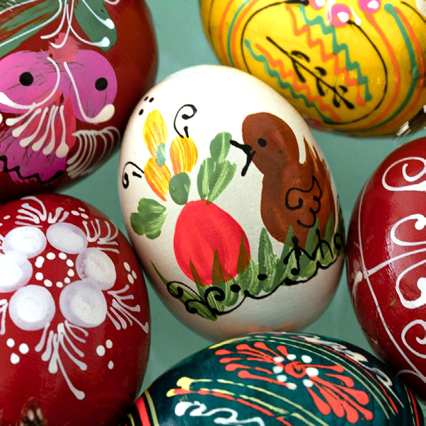 Eine Reihe von Eiern, die in verschiedenen Farben mit unterschiedlichen Mustern und Tiermotiven bemalt sind.