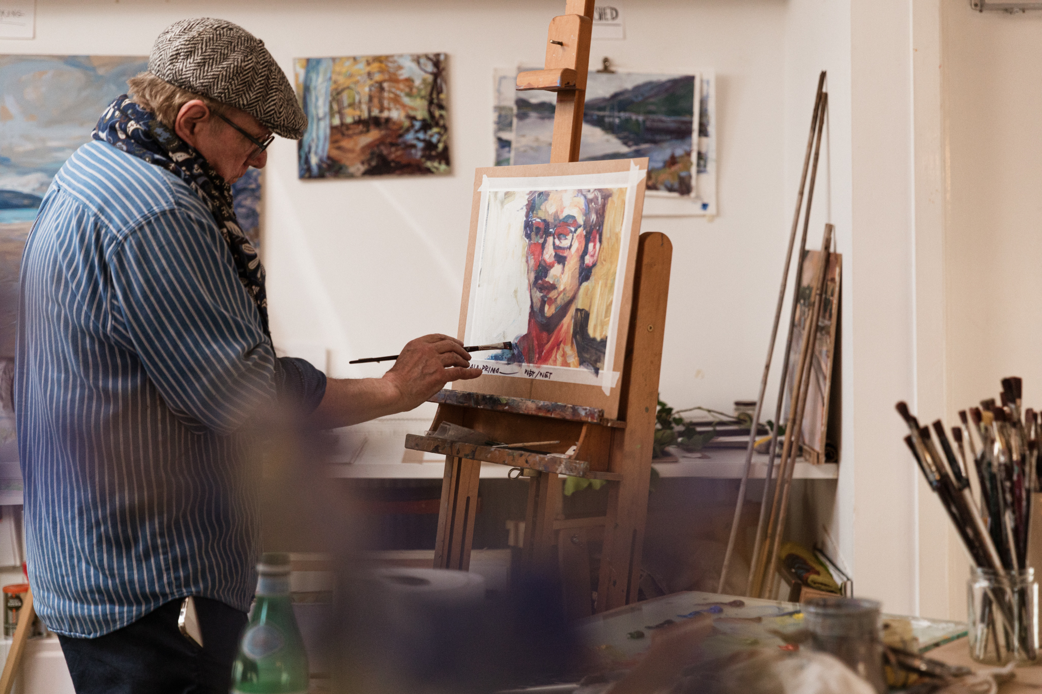 Artist Peter Phillips painting in his studio.
