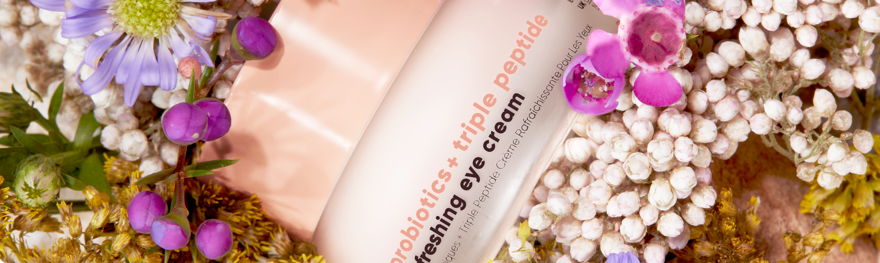 glowoasis vegan probiotics + triple peptide refreshing eye cream eye skincare surrounded by flowers.