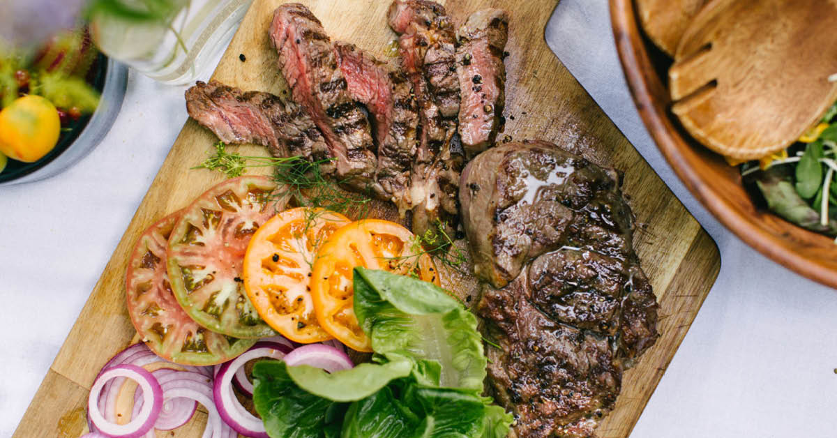 Medium rare beef steaks served on board