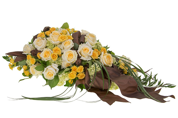 A gorgeous floral casket scarf mixes peach roses and spray roses, pale green hydrangea, lily grass, and Italian ruscus, then is finished with brown satin ribbons.