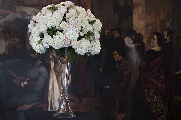 This tall wedding centerpiece, created by FDI Instructor, Jeri Barr, features pale pink roses, white hydrangeas, and spray roses, Israeli ruscus, and plumosa on top of a large crystal vase.