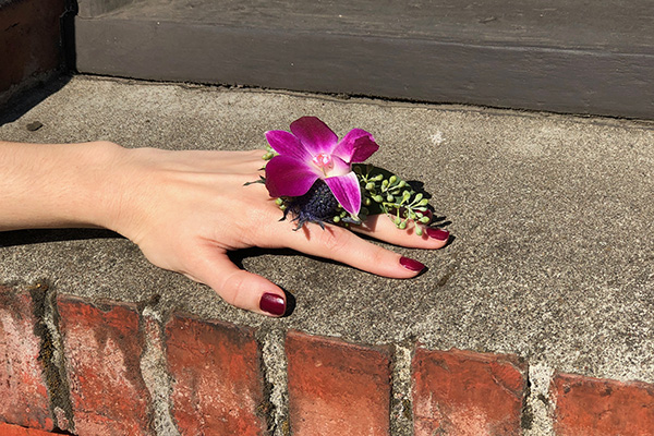 A stylish floral ring is created from a fuchsia orchid matched with seeded eucalyptus and blue eryngium.