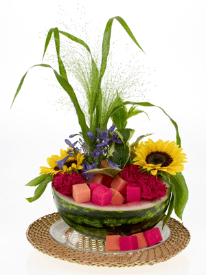 Add sunflowers, red miniature carnations, weigelia, and fountain grass to another watermelon rind for a different style.