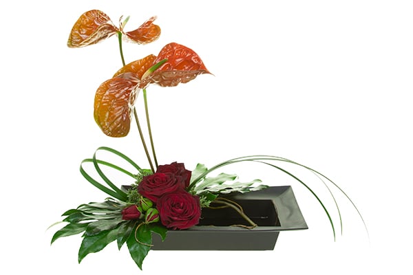 Use lily grass, boxwood, and a few buds from the roses to cover the mechanics and finish the design.