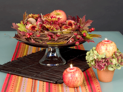 Add a festive autumn table covering and matching components like apples with votive candles in them.