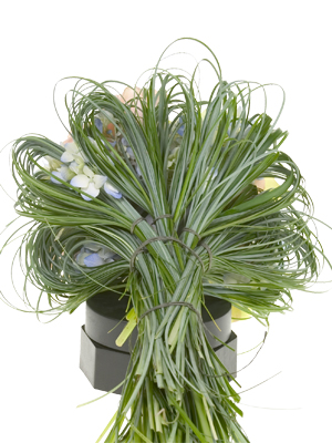 sSlide the bouquet holder into the sleeve of beargrass tufts.