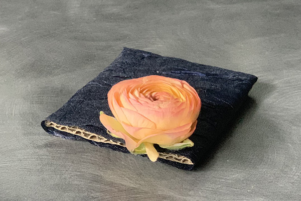 Attach a ranunculus bloom to the ribbon wrapped cardboard.