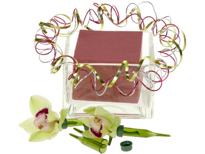 Place foam in the container, then create a wire wreath by coiling the wire around the container. Insert orchid blooms in water tubes.