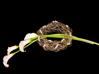 Insert the callas into the wire wreath from one side, across the hole, and back out from the other side.