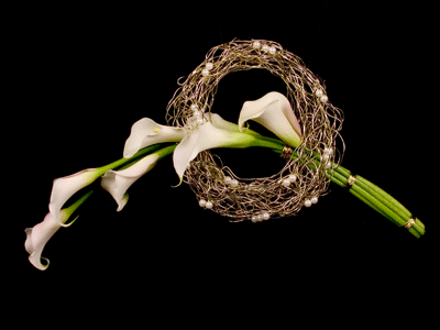 Tuck in additional callas, extending them out with the other stems, then bind the callas at three points with gold bullion wire.