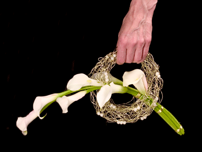 Hold the bouquet by the wreath handle and swing at the side or lift it to the front.