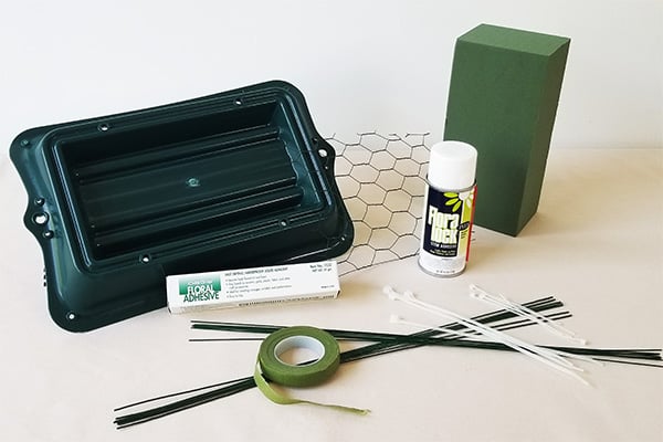 Materials for this design include a casket saddle, floral netting, floral foam, OASIS Floral Adhesive, corsage tape, wires, and cable ties.