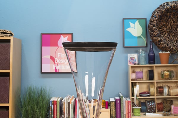 Place the vase with the dish on top of it.