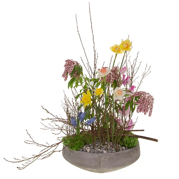 This spectacular floral design in the vegetative style features spring flowers like muscari, daffodils, and sweet peas with green trick dianthus, andromeda, and budding huckleberry branches.