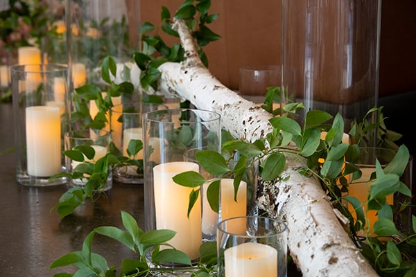 Flowers, candles, foliages and branches lining a wedding aisle.