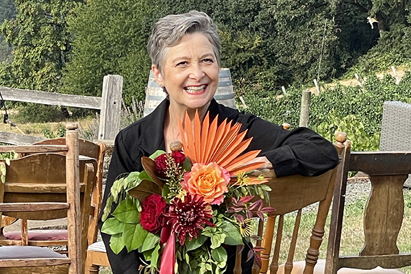 Leanne Kesler seated on a chair with chair back flowers.