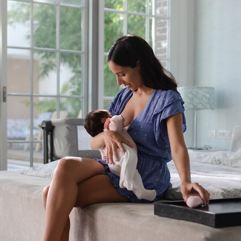 mom breastfeeding baby in bedroom