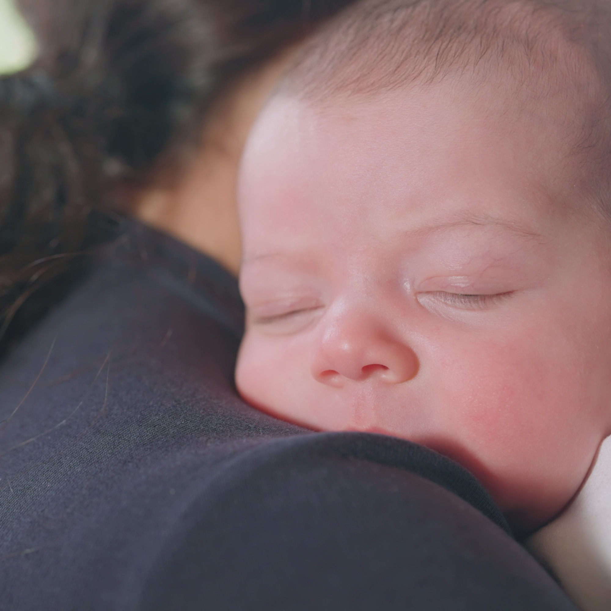 baby asleep at mom's shoulder