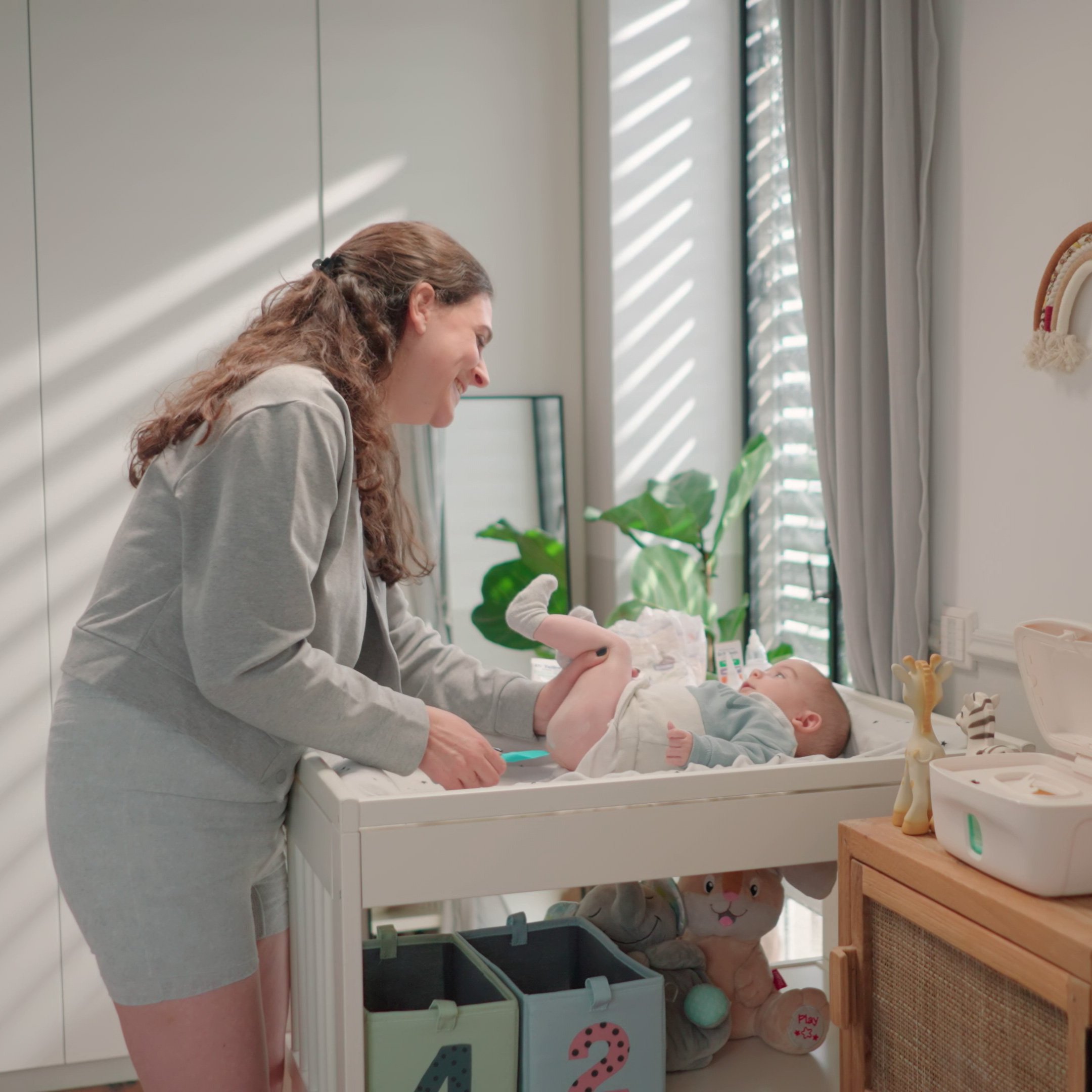 Mom applying diaper rash ointment on baby