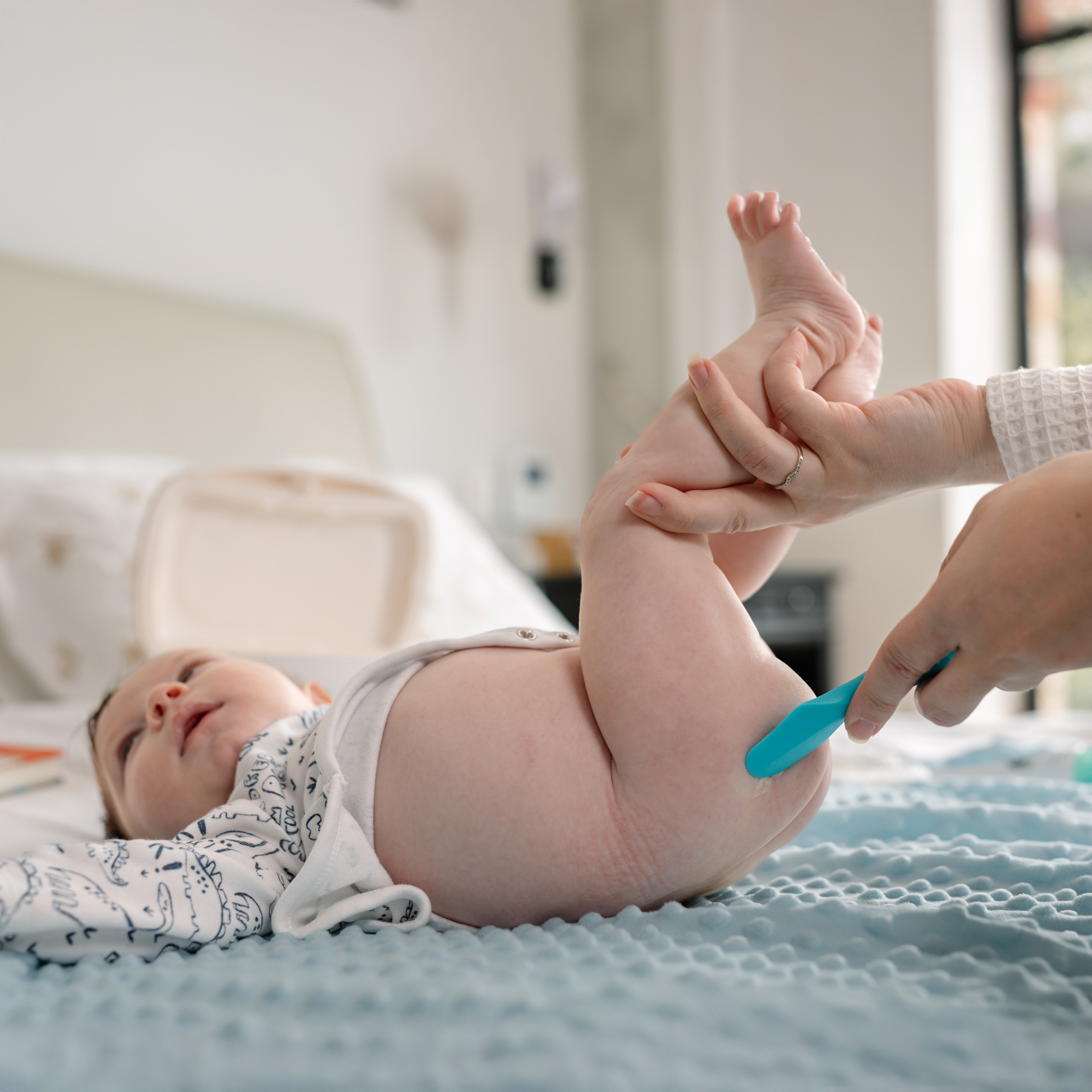 Mom applying diaper ointment on baby