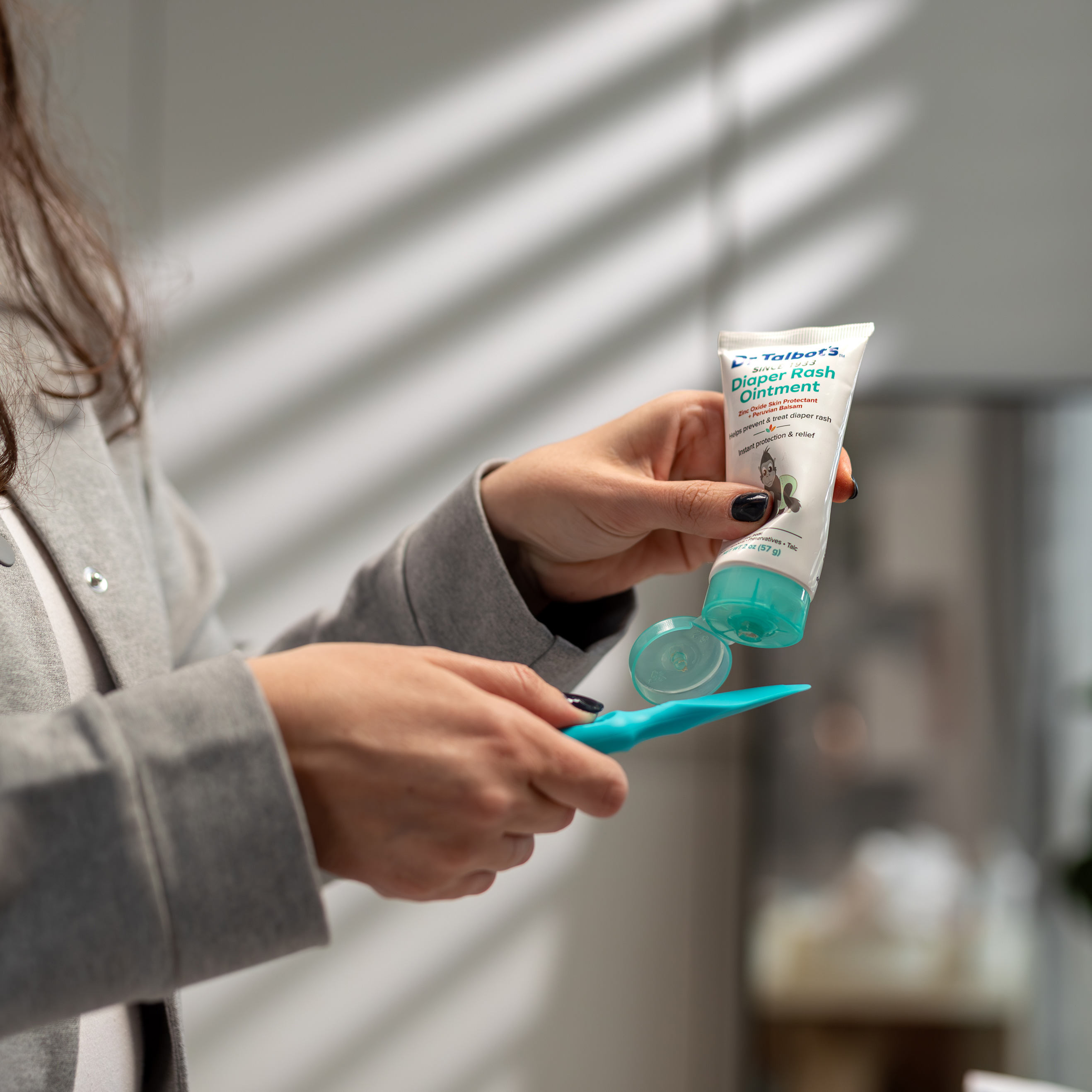 Mom applying diaper rash ointment on brush