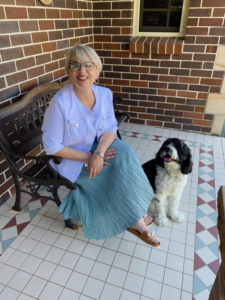 Photo of Michelle seated with her dog.